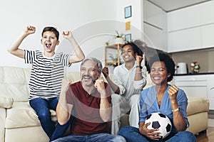 Family football fans watching sport tv game celebrating goal together