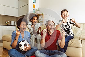 Family football fans watching sport tv game celebrating goal together