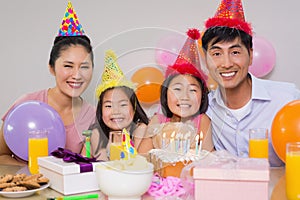 Family of four with cake and gifts at a birthday party