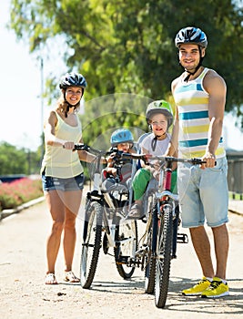 Family of four cycling on street