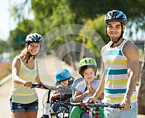 Family of four cycling on street