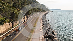 Family of four enjoying in together cycling near the sea, aerial shot