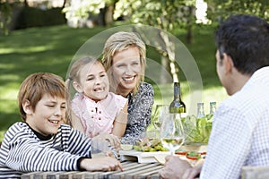 Family Of Four Having Picnic In Park