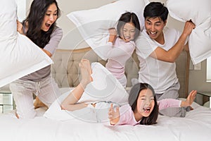 Rodina z čtyři s polštář bojovat na postel 