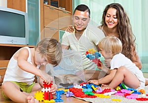 Family of four at home with toys