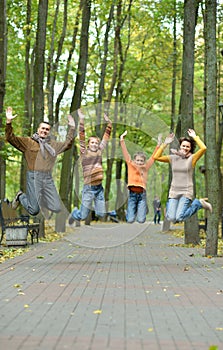 Family of four jumping in autumn park