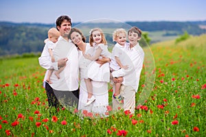 Family with four kids in poppy flower field