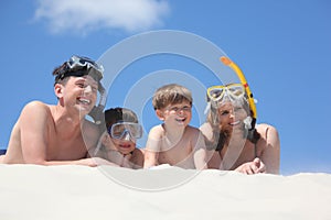 Family of four lying with snorkeling masks