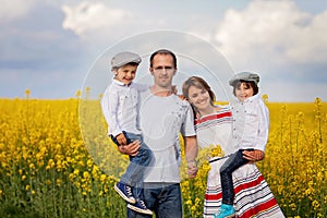 Family of four, mother, father and two boys, in a oilseed f