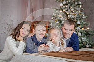 Family of four over cosy Christmas decoration