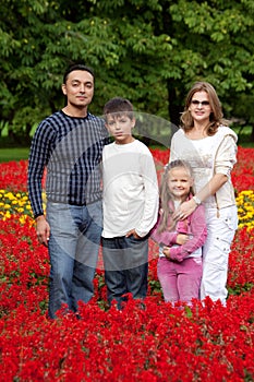 Family of four persons in flowering park