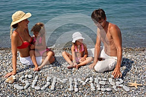 Family from four persons has rest on beach