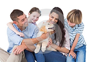 Family of four playing with dog