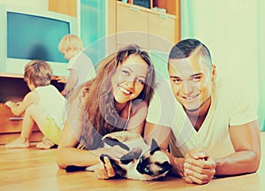 Family of four playing with kitten