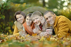 Family of four relaxing in autumn park