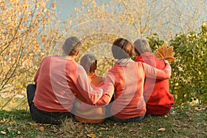 Family of four relaxing in autumn park
