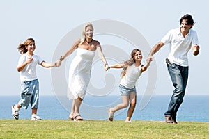 Famiglia da quattro correre sul prato 