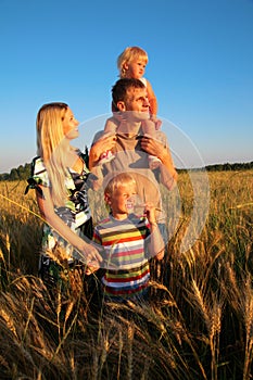 Family of four on sunset wheaten field