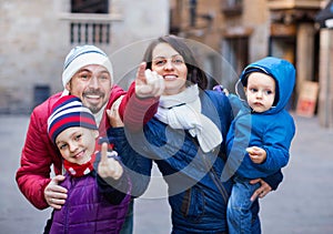 Family of four walking in city and looking showplace