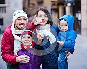 Family of four walking in city and looking showplace photo