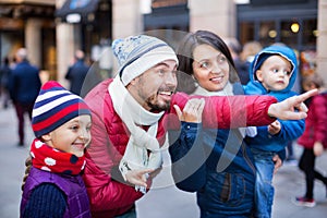 Family of four walking in city and looking showplace photo