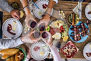 Family and friends clinking and have faun at home during christmas dinner - top view of wooden traditional table with xmas