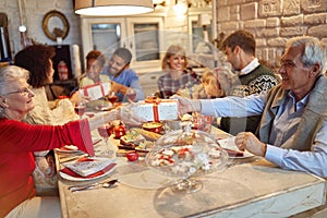 Family and friends enjoy on Christmas dinner and exchange gifts together