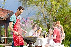 Family and friends having bbq at garden party