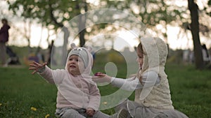 Family, friendship, childhood concepts - Little toddler sister gives purple flower baby infant kid girl in spring park
