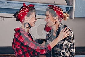 Family, friendship and people concept - happy mother with little daughter. With red lips in a bandana have fun in the home kitchen