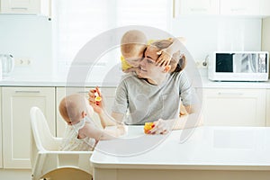 Family fun, mom feeds the children in the kitchen.