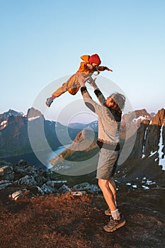 Family fun outdoor father playing with child travel vacations together in mountains dad tossing kid in the air photo