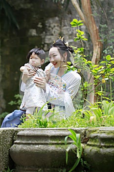 Family fun time, Chinese woman and baby in Hanfu dress enjoy free time