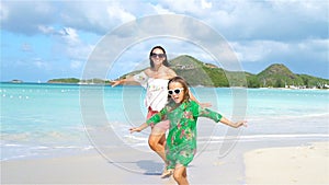 Family fun on white sand. Smiling mother and adorable child playing at sandy beach on a sunny day. SLOW MOTION