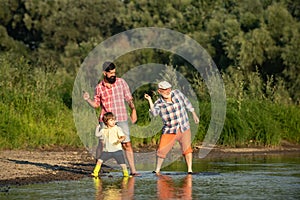 Family game of stone skipping. Three generation family. Father, Son and Grandfather relaxing together.