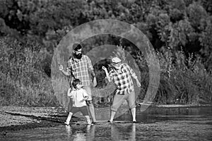 Family game of stone skipping. Three generation family. Father, Son and Grandfather relaxing together.