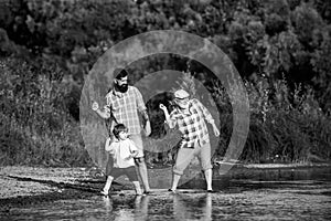 Family game of stone skipping. Three generation family. Father, Son and Grandfather relaxing together.