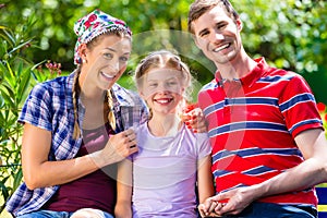 Family in garden sitting on bench