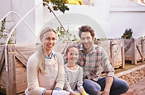 A family that gardens together...Portrait of a happy family taking a break from their gardening.