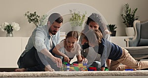 Family gathered in cozy living room play with little children