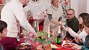 Family gathering around table celebrating christmas