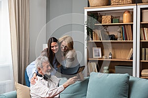 Family gathering. Father, Mother and daughter in the family home, reminisce about the past by looking at old photos from their