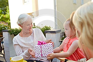 Granddaughter giving present to grandmother