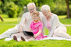 Grandparents and granddaughter with tablet pc