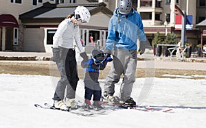 Family Gets Ready to Ski with Toddler Boy. All Dressed Safely with Helmets