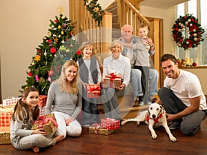 Family with gifts in front of Christmas tree