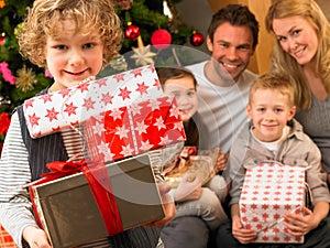 Family with gifts in front of Christmas tree