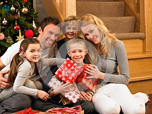 Family with gifts in front of Christmas tree