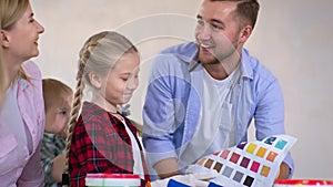 family with girl and boy with disabilities choose paint pigment from color palette for renovation and design in