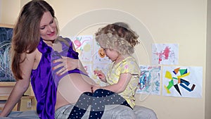 Family girls pregnant mother and toddler daughter girl look after child in tummy